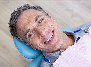 man laying all the way back in chair smiling